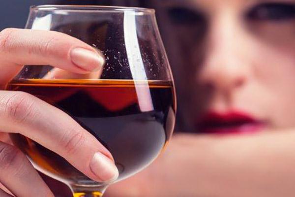 Consumo de álcool: Mulher bebendo uma taça de vinho. 